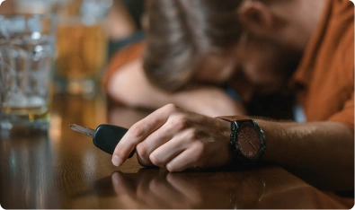 Persona dormida sobre la mesa de un bar con las llaves del auto en la mano
