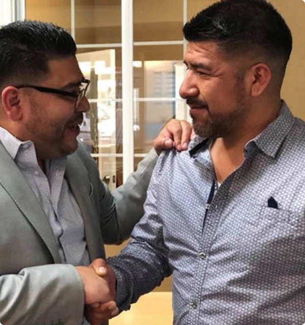 Dos hombres sonriendo y estrechándose la mano