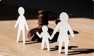 Figuras de papel de una familia junto a un mazo de juez