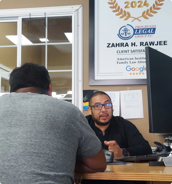 Oficina de abogados con un cliente de espaldas y un certificado en la pared