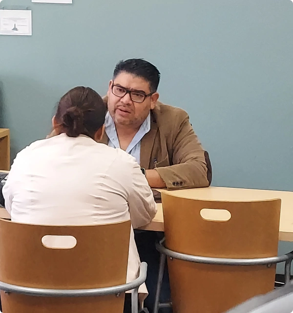 Abogado conversando con una clienta en una mesa