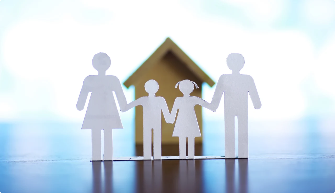 Figuras de papel de una familia bajo un techo