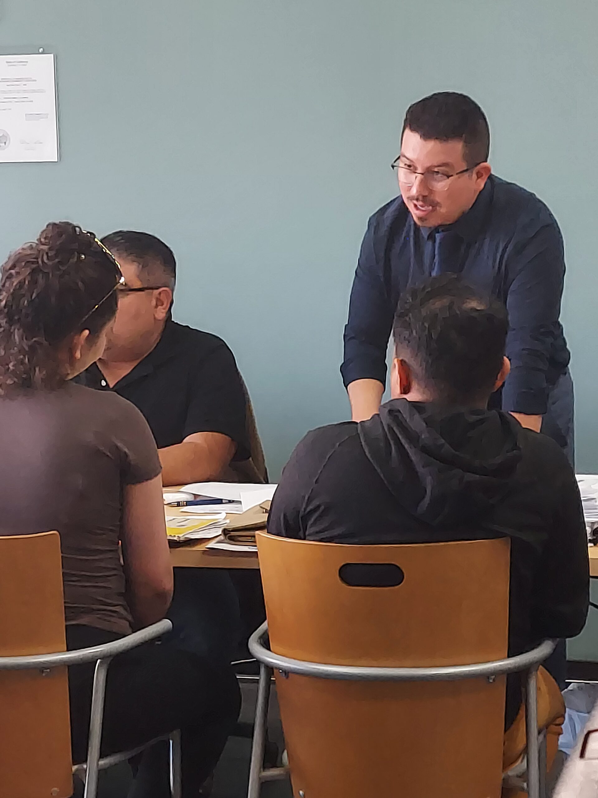 Abogado atendiendo a clientes alrededor de una mesa