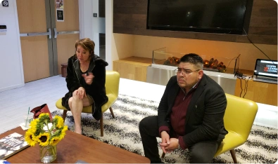Dos personas conversando en una sala de espera