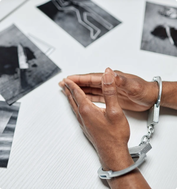Mano esposada sobre fotografías de evidencia