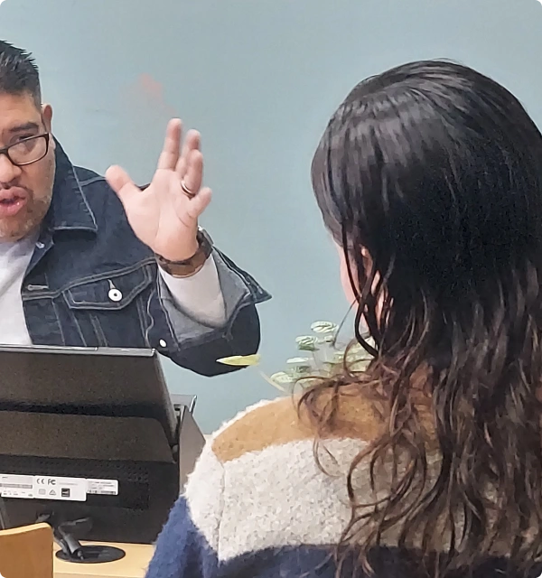 Abogado explicando el caso a una clienta frente a su computadora