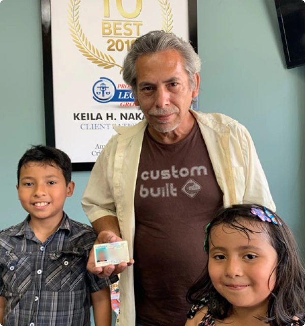 Hombre mayor con una niña y un niño sonriendo en una oficina