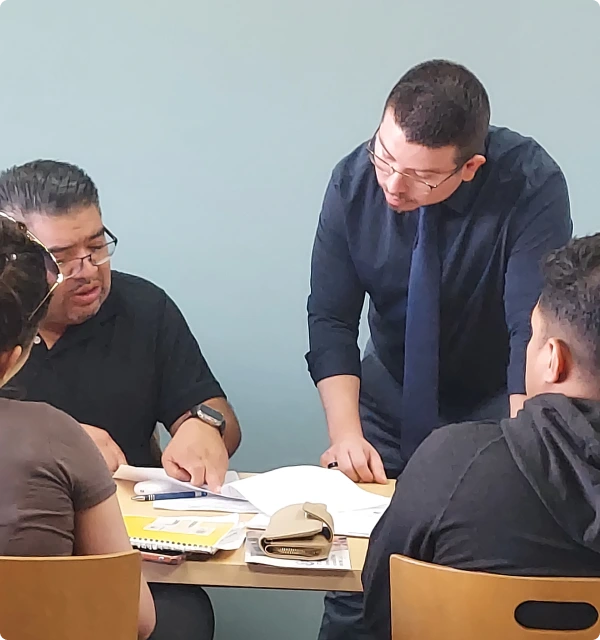 Abogados reunidos con clientes alrededor de una mesa