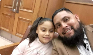 Padre y su hija sonriendo ante la cámara