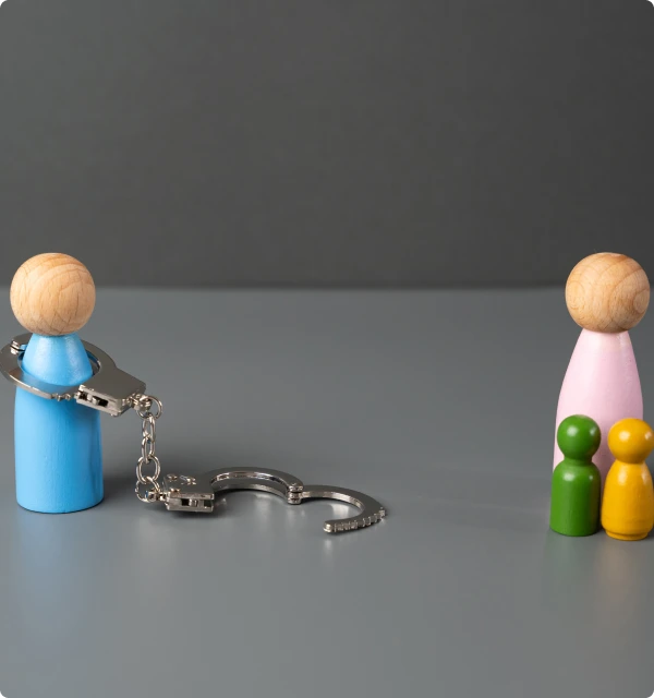 Figuras de una pareja separadas por una cadena y unas esposas