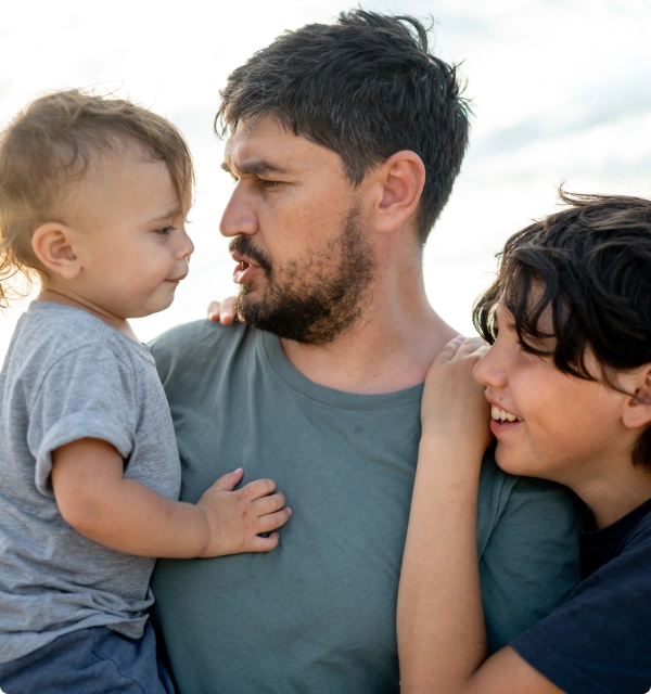 Padre sonriendo con sus dos hijos