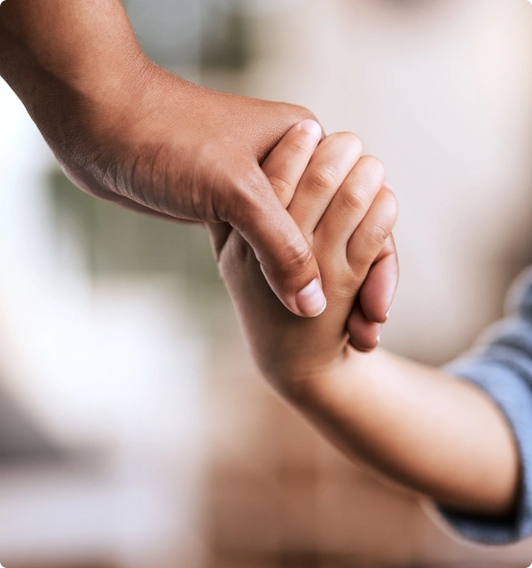 Mano de un adulto sosteniendo la mano de un niño