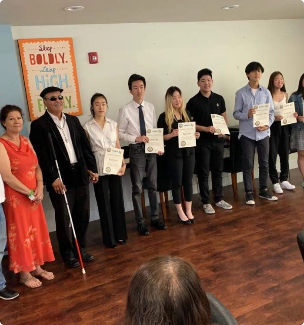 Grupo de personas posando con certificados en una oficina
