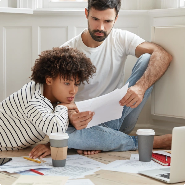 Padre e hijo revisando documentos en el piso de la sala