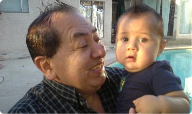 Abuelo sonriendo con un bebé en brazos