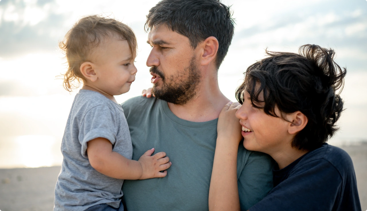 Padre sonriendo con sus dos hijos